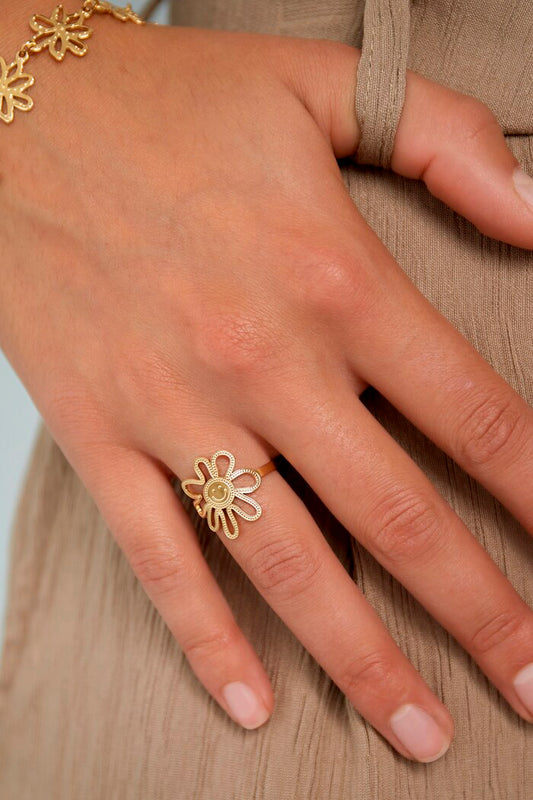 El anillo Happy Flower, es una pieza única que combina una delicada flor con una adorable carita sonriente en el centro. Fabricado en acero inoxidable dorado.