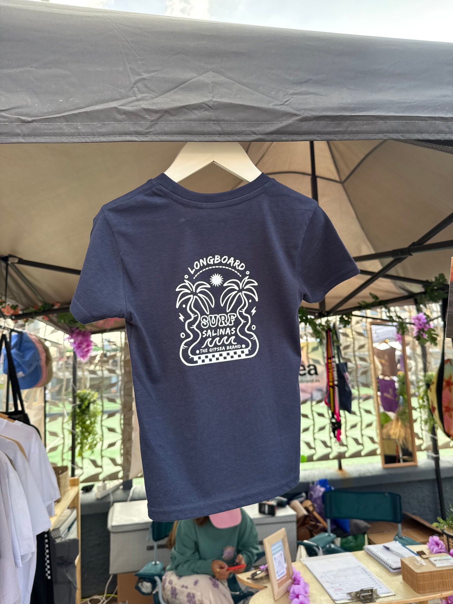 Con un diseño gráfico que celebra el deslizamiento suave sobre el asfalto o las olas, y confeccionada en algodón orgánico