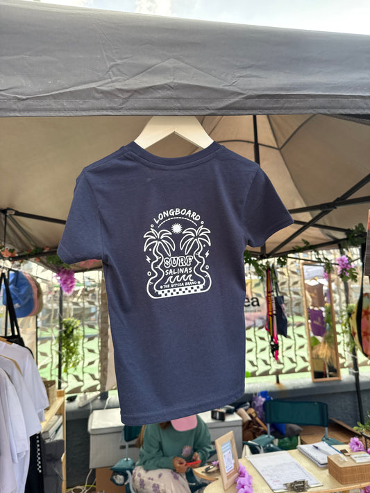 Con un diseño gráfico que celebra el deslizamiento suave sobre el asfalto o las olas, y confeccionada en algodón orgánico
