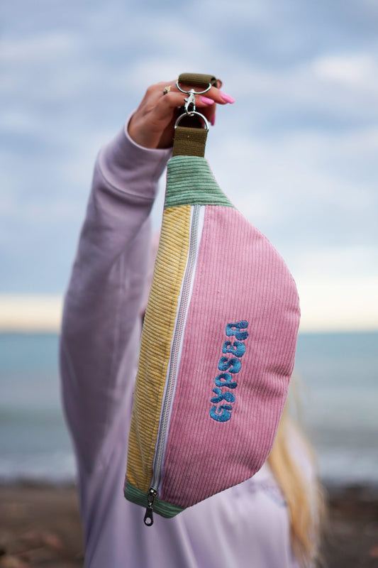 Fabricadas en una combinación de color azul marino, rosa y amarillo, estas riñoneras destacan por su textura suave y su diseño moderno.

Cuentan con un cordón ajustable y enganches resistentes.